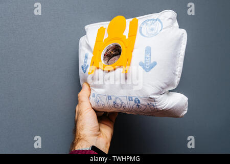 Paris, France - 16 mai 2019 : Man hand holding contre l'arrière-plan gris utilisé avec de la poussière plein les sacs aspirateur Swirl modèle S67 pour Siemens et Bosh - produit de qualité allemande Banque D'Images