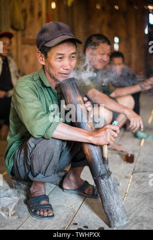 L'homme par l'opium de fumer le tabac traditionnel tuyau dans l'akha Pixor village près de Phongsali, Laos. Banque D'Images