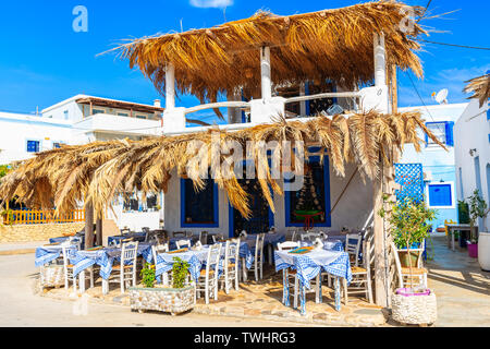 Des tables et des chaises dans la taverne grecque traditionnelle à Finiki port sur l'île de Karpathos, Grèce Banque D'Images