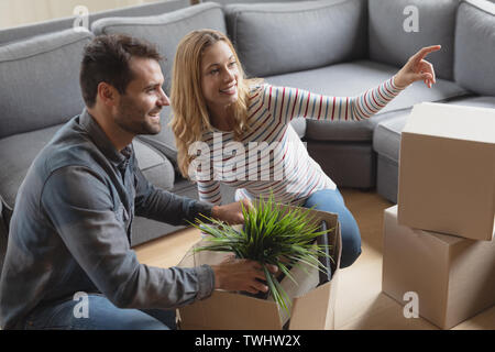Femme montrant quelque chose à l'homme lors du déballage Banque D'Images