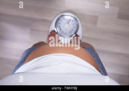 Un portrait d'un excès de femme debout sur l'échelle sur plancher de bois franc Banque D'Images