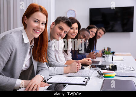 Groupe multiracial de Happy Woman Sitting in Row Looking at Camera Banque D'Images