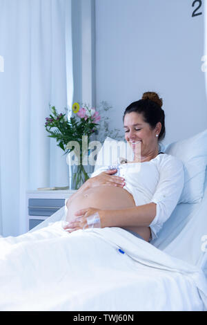 Pregnant woman touching her belly in the ward Banque D'Images