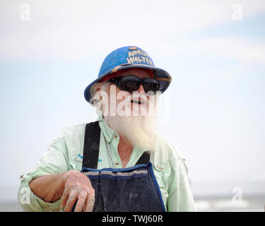 Barbe blanche Amazin', 'Walter' McDonald dans un pith helmet prend une pause à partir de la sculpture à la Texas 2019 Sandfest à Port Aransas, Texas USA. Banque D'Images