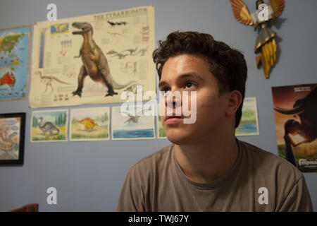 Marietta, GA, USA. 15 Juin, 2019. Eric Ruiz, 22 ans, qui connaît l'autisme, est un 'Dinosaur Master' et passe beaucoup de son temps à la fenêtre de sa chambre à coucher à la maison de ses parents. Il est capable de vivre à la maison au lieu d'une maison de soins infirmiers ou un service vivant aidé à cause de renonciation qui fournit le financement Medicaid formé le personnel professionnel de soutien direct qui l'emmène en excursion dans la communauté, plusieurs jours par semaine, apprendre à naviguer dans la société. Crédit : Robin Rayne/ZUMA/Alamy Fil Live News Banque D'Images