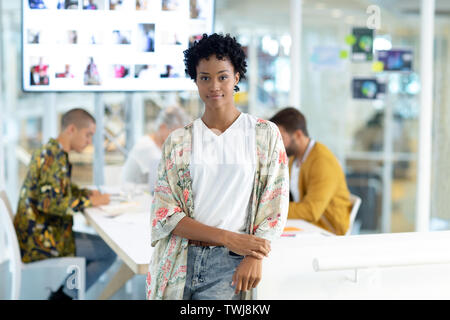 Designer de mode féminine s'appuyant sur une table dans la salle de conférence in office Banque D'Images