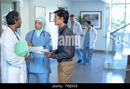 L'équipe médicale des médecins qui parlent les uns avec les autres dans le hall. Banque D'Images
