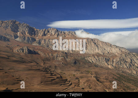 Sur la montagne majestueuse - pics rocheux avec des pentes herbeuses flétri brunâtre sous ciel bleu avec des nuages blancs aveuglante Banque D'Images