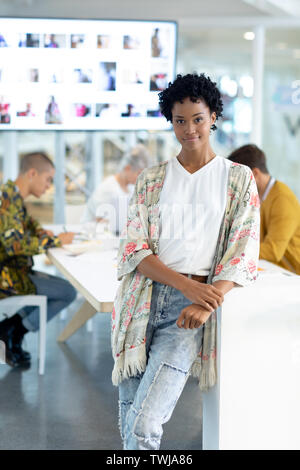 Designer de mode féminine s'appuyant sur une table dans la salle de conférence in office Banque D'Images