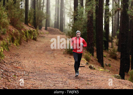 Homme qui court dans les bois de la forêt de formation et d'exercices pour l'exécution de la course d'endurance trail marathon. Vie saine remise en forme de l'athlète masculin avec concept Trail Runner. Banque D'Images