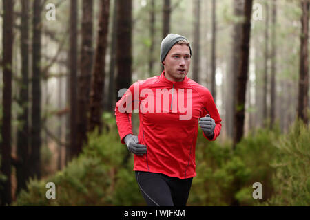 Homme en train de courir dans les bois de la forêt de formation et d'exercices pour l'exécution de la course d'endurance trail marathon. Vie saine remise en forme de l'athlète masculin avec concept Trail Runner. Banque D'Images