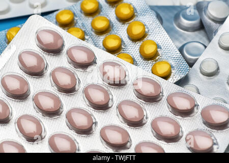 Pile de médecine colorés pills and capsules . Un grand nombre de paquets de pilules multicolores gisant sur fond bleu Banque D'Images