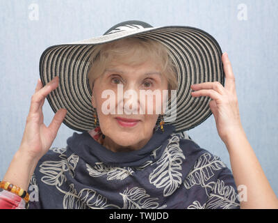 Studio head and shoulders portrait of a senior woman in chapeau à large Banque D'Images