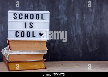 School is Cool lettrage sur pile de livres. L'écriture noire sur fond de bureau Banque D'Images