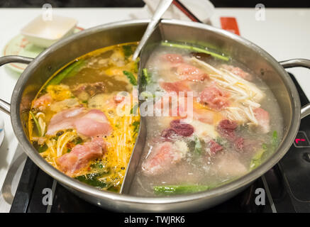 Viande cuisine shabu shabu avec légumes bouillis dans deux types soup Banque D'Images