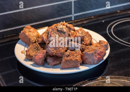 Tranches de filet de boeuf à l'ail sur plaque blanche dans la cuisine Banque D'Images