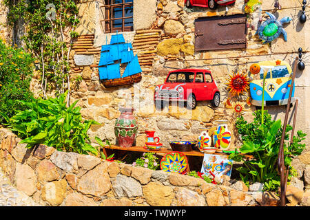 TOSSA DE MAR, ESPAGNE - juin 3, 2019 : affichage sur mur avec des souvenirs touristiques dans rue étroite avec des maisons en pierre dans la vieille ville de Tossa de Mar, Costa B Banque D'Images