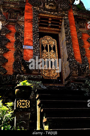 Les grandes portes d'entrée en bois décorés et pierre Bedogol comme protecteurs, Ubud, Bali, Indonésie Banque D'Images