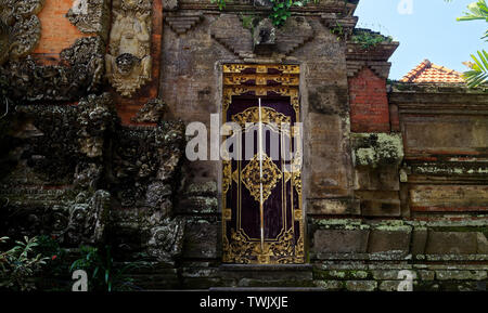 Les grandes portes d'entrée en bois décorés et pierre Bedogol comme protecteurs, Ubud, Bali, Indonésie Banque D'Images