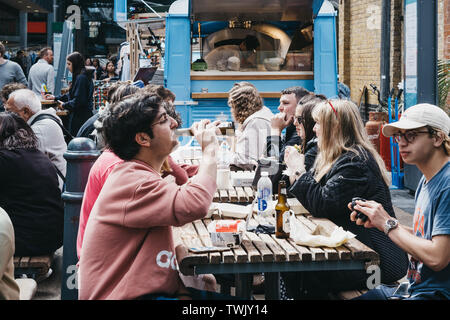 Londres, Royaume-Uni - 15 juin 2019 : les personnes bénéficiant de l'alimentation et des boissons à l'intérieur du Marché de Spitalfields, l'une des plus belles salles de marché victorien survivant à Londres w Banque D'Images