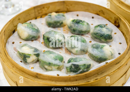 Ha gow rempli de légumes dans la pâte feuille. dim sum chinois dans panier de bambou Banque D'Images