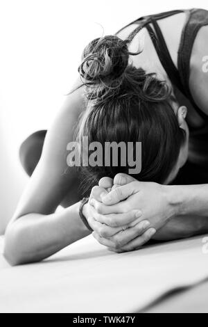 Close-up vertical d'une méconnaissable, dark-haired femme européenne faisant la posture de l'Étoile ou Tarasana la posture de yoga. Banque D'Images