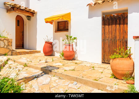 Pots de fleurs en face de la maison blanche typique de village de pêcheurs côtiers de Sa Tuna, Costa Brava, Espagne Banque D'Images