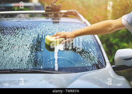 Lave-main lavage de voiture - pare-brise avec une éponge Banque D'Images
