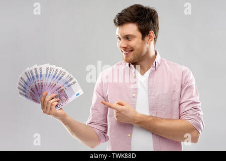 Smiling young man fan de euro argent Banque D'Images