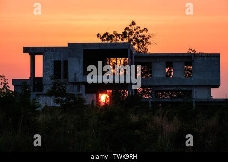 Ancien bureau d'accueil des déchets de construction en terre avec le coucher du soleil sur le canal Banque D'Images