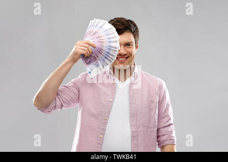 Smiling Young man with fan de euro argent plus de Gray Banque D'Images