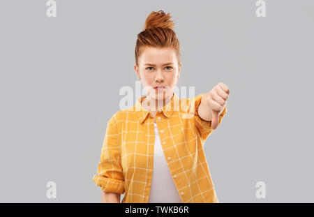 Angry red haired woman showing Thumbs down Banque D'Images