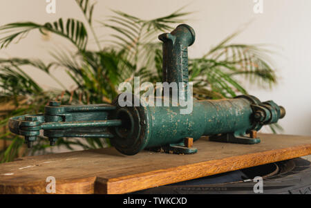 Ancien, vintage, style rétro, la pompe à eau manuelle Vassen sur planche de bois et l'arrière-plan de l'usine Banque D'Images