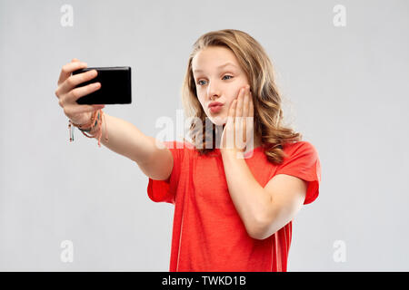 Smiling teenage girl taking smartphone par selfies Banque D'Images