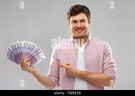 Smiling young man fan de euro argent Banque D'Images