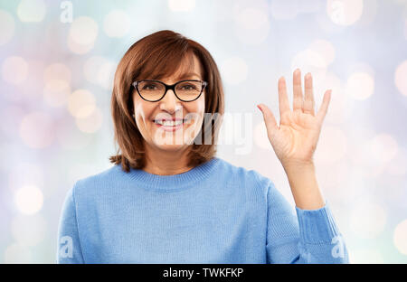 Portrait of senior woman dans les verres en agitant la main Banque D'Images