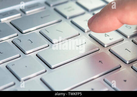 Doigt appuyant sur le bouton du clavier. Cliquez sur la touche grise ultrabook Banque D'Images