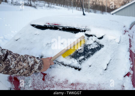 Côté conducteur à l'aide d'une brosse sur le pare-brise de la neige en voiture d'hiver orageux Banque D'Images