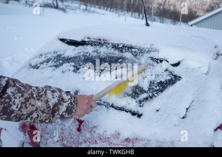 Côté conducteur à l'aide d'une brosse sur le pare-brise de la neige en voiture d'hiver orageux Banque D'Images