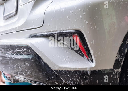 Lavage de voiture avec du savon bulle arrière sur voiture suv blanc Banque D'Images