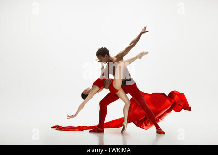 Ballet classique danse danseurs gracieux isolated on white background studio. En quelques vêtements rouge vif comme une combinaison de vin et de lait. La grâce, l'artiste, de mouvement, d'action et de motion concept. Banque D'Images