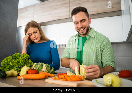 Femme n'aime pas quand son mari est la cuisson. Banque D'Images