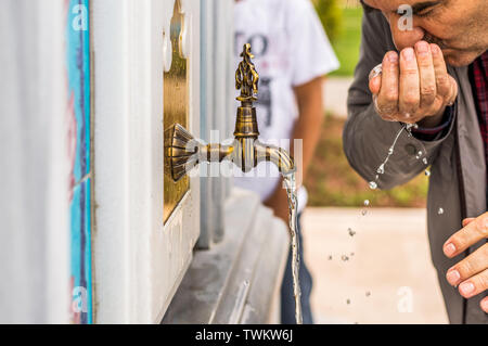 L'eau potable l'homme avec sa main d'une antique fontaine turque sur un mur de marbre. Fonctionnement de l'eau du robinet. Banque D'Images