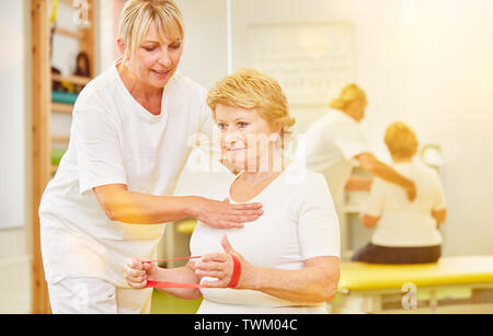 Avec Theraband senior à la physiothérapie permet la formation de force pour correction posturale Banque D'Images