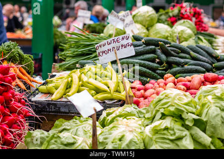 Divers légumes frais sur le marché de Belgrade. Vendeurs et clients sur floue fond. Lettres ОЧИШЋЕНИ КРОМПИРИЋИ «' signifie 'CLEAN POTAT Banque D'Images