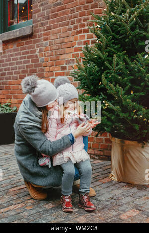 Mère avec enfant girl drinking hot chocolate café au célèbre marché de noël vacances du Nouvel An. Activité de plein air en hiver en famille. Maman et daughte Banque D'Images