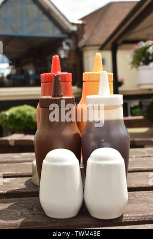 Les bouteilles de condiments, photographié sur une table sur la Highstreet Ashford Banque D'Images