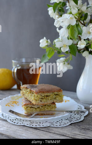Remplissage avec du chou à tarte sur une plaque sur une table en bois avec un gris vase de fleurs, avec une tasse de thé et de citron.Les produits de boulangerie Banque D'Images