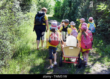 18 juin 2019, la Saxe-Anhalt, Mücheln-Stöbnitz : les enfants du groupe ant du jardin d'aventure 'Rainbow' dans Mücheln-Stöbnitz à pied avec leur éducateur Jennifer Geheb et un diable avec de l'eau fraîche de leur petit abri fortifié à la tour d'observation Geiseltalsee à travers la forêt. Tous les jours jusqu'à 12 enfants d'âge pré-scolaire et leurs enseignants d'explorer la nature et de l'richement boisée, non loin du plus grand lac artificiel d'Allemagne. Le concept pédagogique est basé sur une proximité de la nature et de l'apprentissage expérientiel. Photo : Waltraud Grubitzsch/dpa-Zentralbild/ZB Banque D'Images