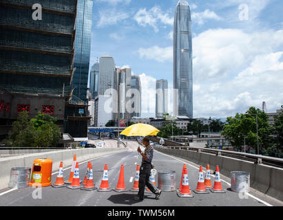 Un manifestant tient un parapluie jaune, un symbole utilisé lors de l'Égide, mouvement à un cône temporaire barricade lors de la dernière manifestation à Hong Kong. Malgré le chef de la carrie Lam a tenté d'atténuer les tensions en acceptant de suspendre le controversé projet de loi sur l'extradition, des groupes d'étudiants et de l'union a continuer la protestation contre le gouvernement de Hong Kong. Les manifestants ont demandé le retrait de la controversée LOI SUR L'extradition, la libération et la non-poursuite des gens arrêtés en raison de la cause, de savoir si une force excessive a été utilisée par la police le Banque D'Images